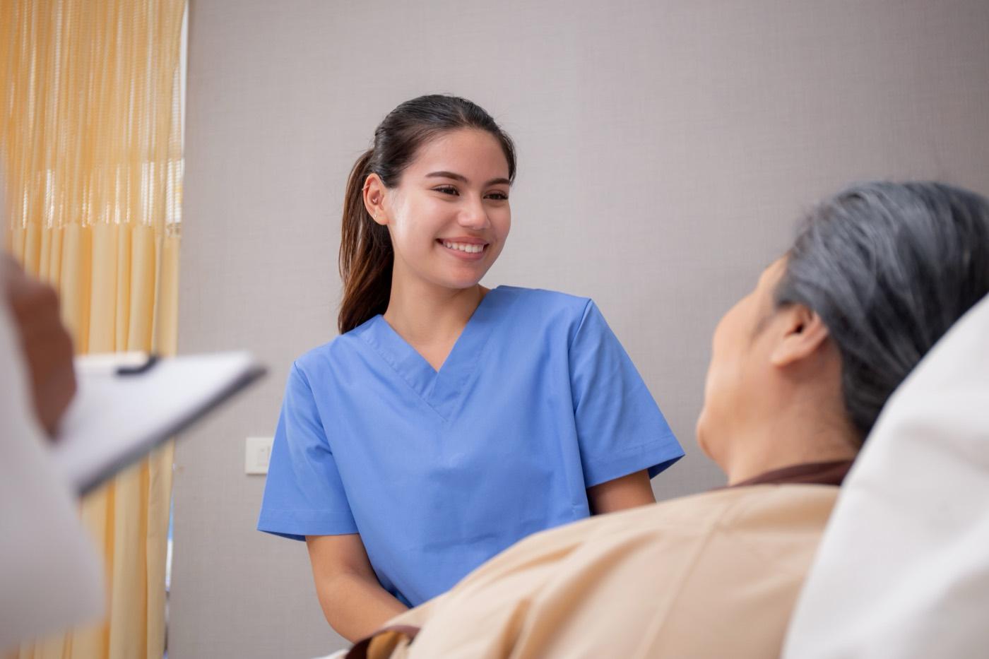 A caregiver speaks with an older adult who is recovering at home.